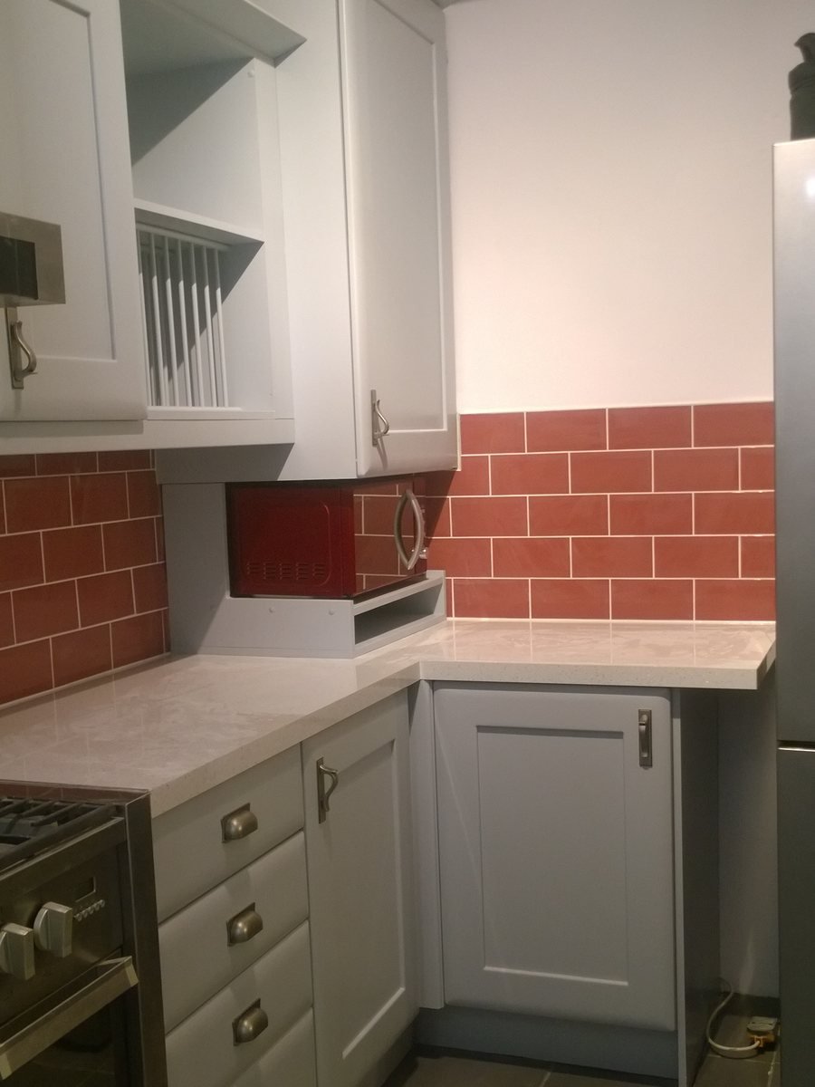 The same kitchen with the units refinished and the splashback painted out