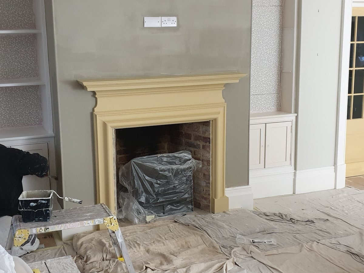 A fire surround stripped back with the hearth and floor sheeted up