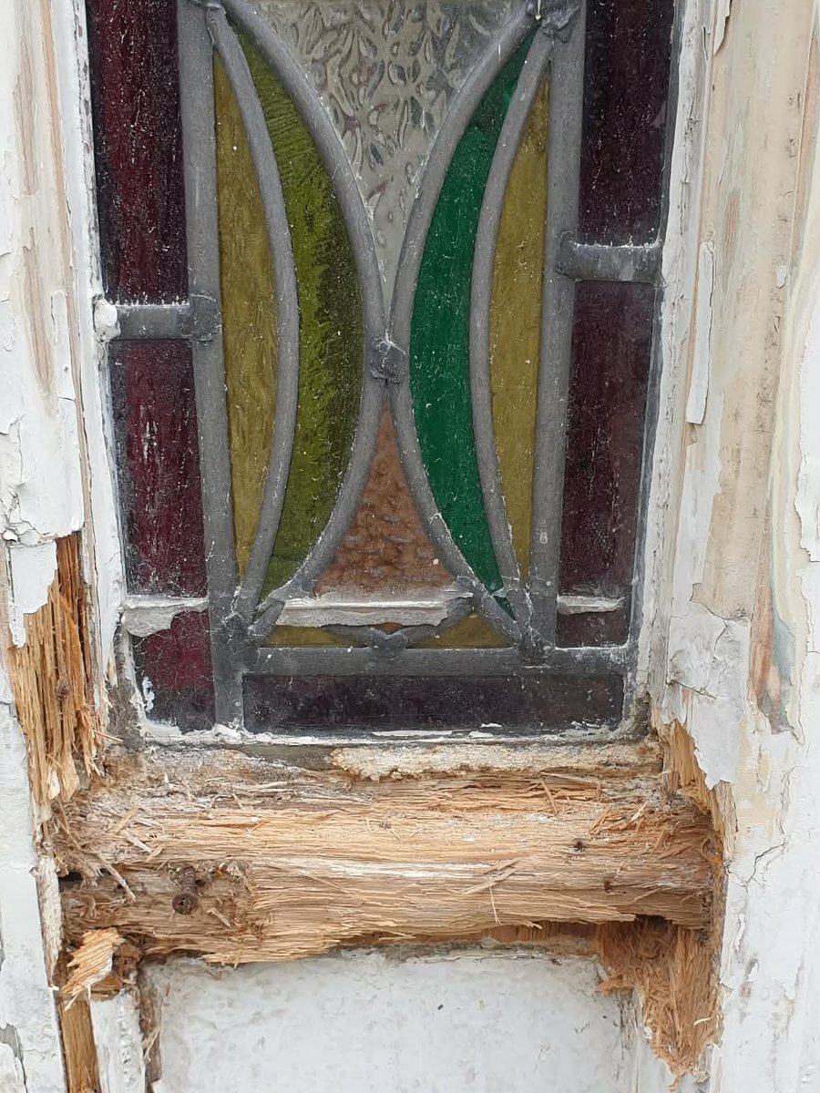 A Victorian front door with the timber rail below the stained glass rotted through