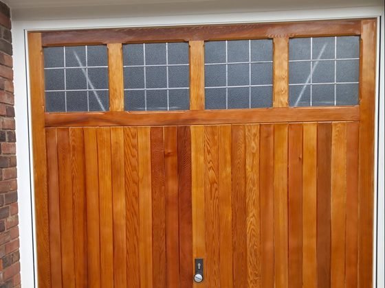 A garage door restored and stained in a rich warm brown