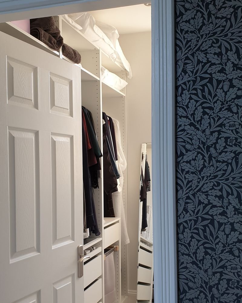 Dark botanical heritage wallpaper beside a painted panel door