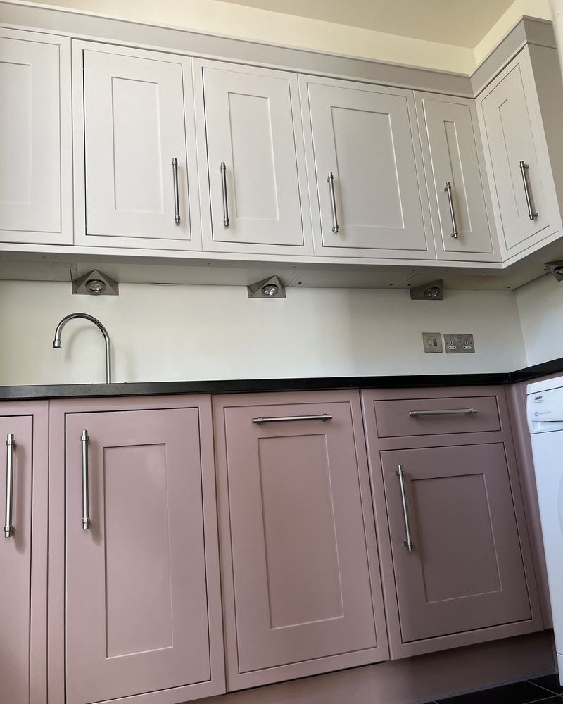 Kitchen units hand-painted in dusty pink with a black worktop