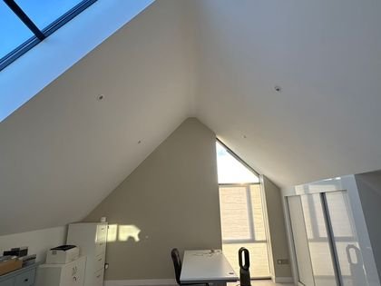 Painted sloping ceiling and skylight in the same loft room