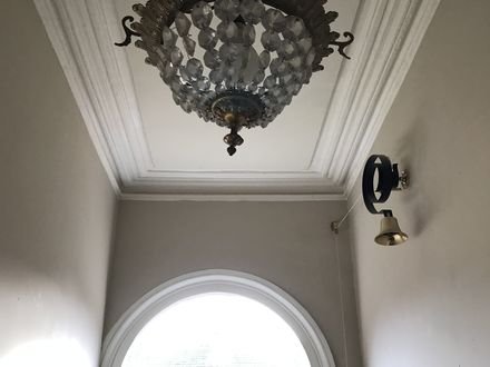 A restored period hallway with arched fanlight door and ornate cornice