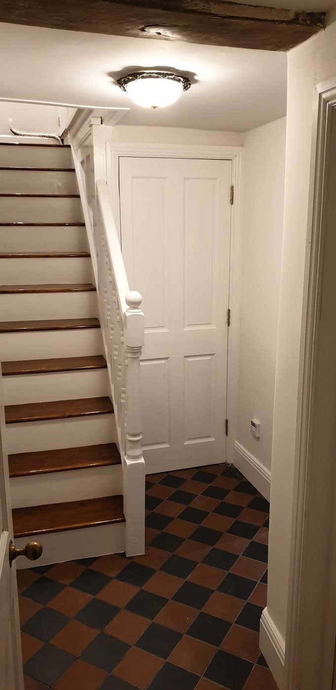 The finished staircase painted, above a tiled hall floor