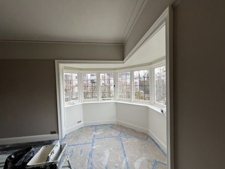 A finished bay-window room, walls and ceiling re-plastered and painted