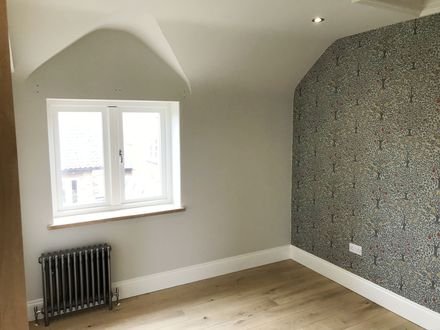 Botanical wallpaper hung in an alcove beside a window