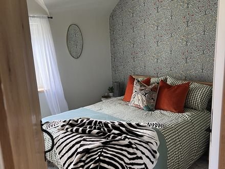 A bedroom finished in botanical wallpaper